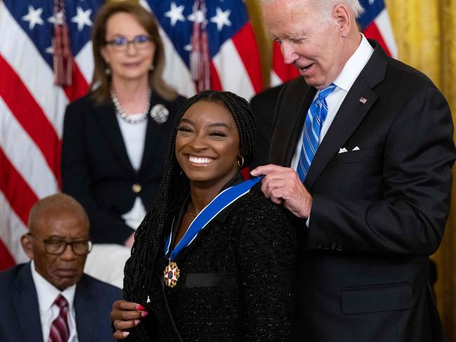 US President Joe Biden presents Gymnast Simone Biles with the Presidential Medal of Freedom, the nation's highest civilian honor, during a ceremony honoring 17 recipients, in the East Room of the White House in Washington, DC, July 7, 2022. (Photo by SAUL LOEB / AFP)