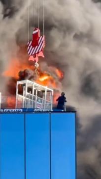 Onlookers capture dramatic moment a worker is trapped on top of burning building