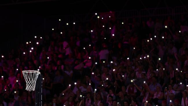 Fans hold their phones as torches during the power cut.