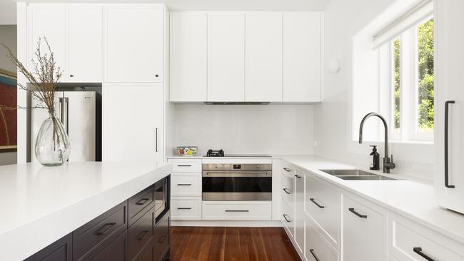 The freshly renovated kitchen has a stone topped island bench and a large oven.