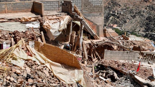 A survivor searches for some belongings under the rubble of his destroyed house in the earthquake-hit town of Afella, Ighir on September 17. (Photo by FETHI BELAID / AFP)