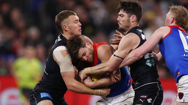 Jack Viney of the Demons is gang tackled by Patrick Cripps and George Hewitt of the Blues. Picture: Michael Klein