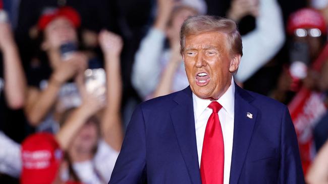 Former US President and Republican presidential candidate Donald Trump gestures as he walks on stage during a campaign rally at Van Andel Arena in Grand Rapids, Michigan on November 5, 2024. (Photo by KAMIL KRZACZYNSKI / AFP)