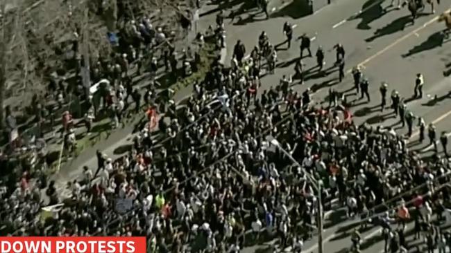 Hundreds have begun marching in Melbourne, where police are trying to hold them back. Picture: ABC News