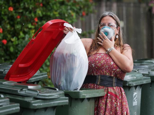 The pungent aroma of prawn heads and meat scraps has been filling the warm, humid air on roadsides around Cairns this week, after the excesses of Christmas Day have passed and the smelliest bin day of the year approaches. Michelle de Ron took some extra precautions while throwing out a bag full of old prawns, seafood and oyster shells into the kerbside collection in front of her house on Little Street, Manunda. Picture: Brendan Radke