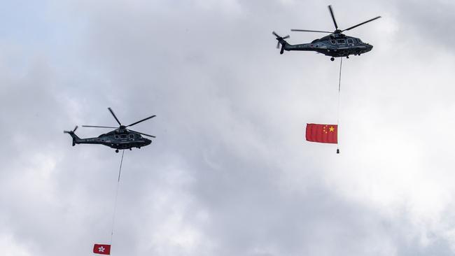 The Chinese (R) and Hong Kong (L) flags are flown past by helicopter over Victoria Harbour during a flag-raising ceremony to mark the 23rd anniversary of Hong Kong's handover from Britain. Picture: AFP.