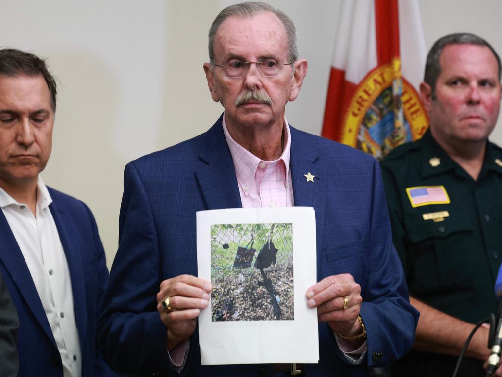 Palm Beach County Sheriff Ric Bradshaw holds a photograph of the rifle and other items found near where a suspect was discovered during a press conference. Picture: Getty Images via AFP