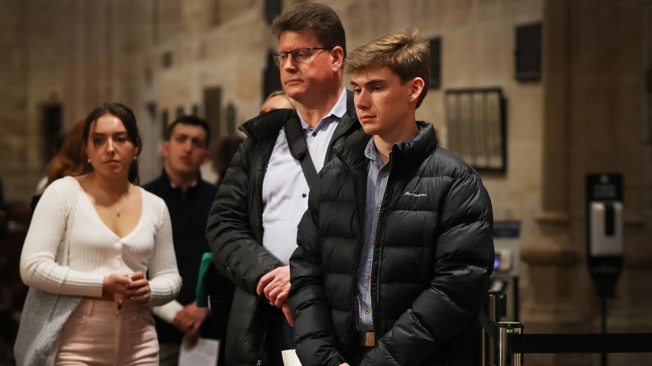 Sydney, Australia: A family queue to leave messages of condolences for Queen Elizabeth II at St. Andrew's Cathedral on September 19, which included a telecast of the funeral. Picture: Getty Images