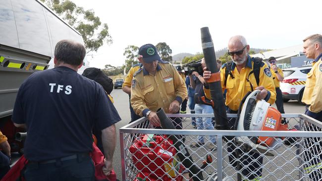 Firefighters from the TFS and Rural Fire Service load equipment onto buses ready to assist firefighting efforts. Picture: NIKKI DAVIS-JONES