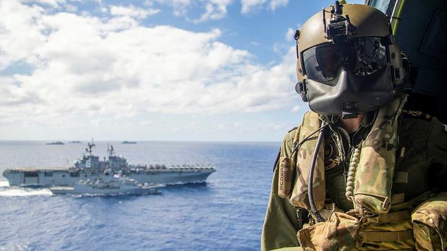 Petty Officer Aircrewman Leeann Mumby watches a replenishment at sea between HMAS Ballarat (front) and USS America on Tuesday. Picture: LSIS Ernesto Sanchez/ADF