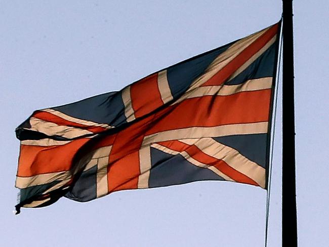 A British Airways passenger aircraft is pictured beyond a Union flag as it flies atop the Victoria Tower at the Houses of Parliamnet in central London on January 28, 2019. - Despite the humiliating rejection of Prime Minister Theresa May's Brexit deal, Britain is no closer to knowing the end result of its vote to leave the European Union. A raft of amendments to be voted on by MPs on Tuesday threaten to further muddy the waters as the clock ticks down to Britain's scheduled departure from the EU on March 29. (Photo by Tolga AKMEN / AFP)