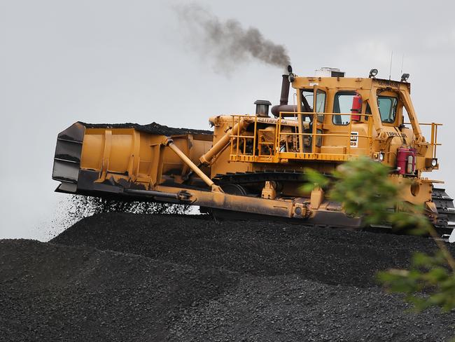 CMNEWS_Trucks arrive with coal from New Hope Mine to Jondaryan station to load coal to awaiting trains headed for the port today Tuesday Feb 10th, 2015. Pictures: Jack Tran / The Courier Mail