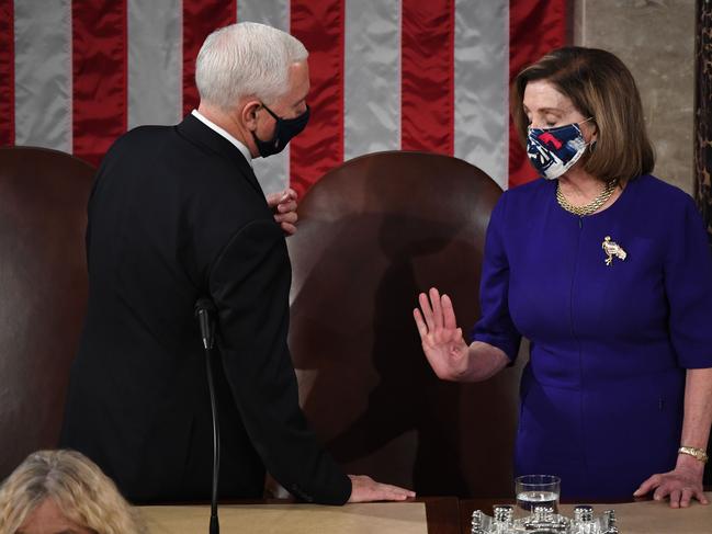 Mike Pence and Nancy Pelosi in Congress before counting was halted by the violence. Picture: AFP.