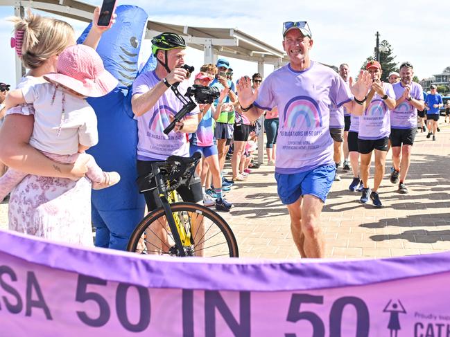 JANUARY 11, 2025: Asa Cowell finishes running his 50th marathon in 50 days at Seacliff raising money for Catherine House. Picture: Brenton Edwards