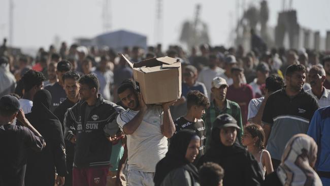 Palestinians carry boxes containing food and humanitarian aid packages delivered by the Gaza Humanitarian Foundation. Picture; AP.