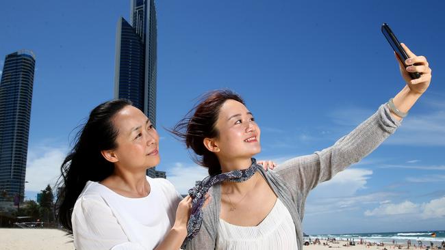 Chinese tourists Nana Chao and Qiqi Si enjoy time on Surfers Paradise beach as Chinese visitors are pour in at record levels. Pics Adam Head