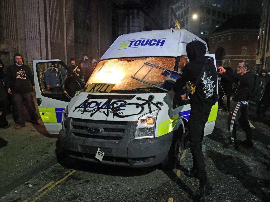 Protesters set fire to a vandalised police van outside Bridewell Police Station on Sunday. Picture: Andrew Matthews/PA Wire /AAP