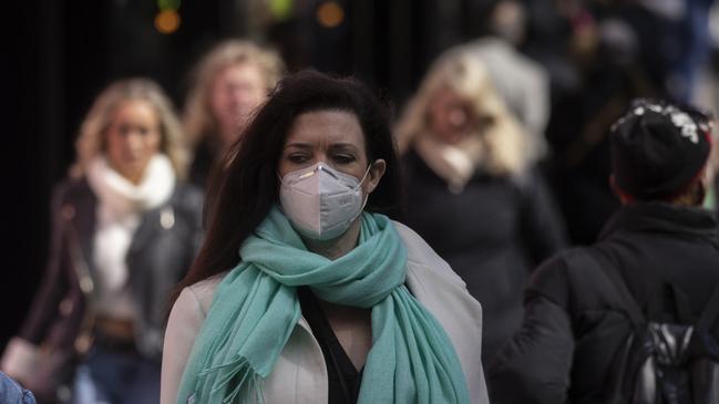 LONDON, ENGLAND - APRIL 01: A woman wears a face mask while walking on Oxford Street on April 01, 2022 in London, England. From today, guidance on voluntary COVID-status certification in domestic settings and the use of the NHS Covid Pass plus requirements for employers to consider COVID-19 in health and safety risk assessments is removed. Free universal symptomatic and asymptomatic testing for the general public is no longer provided with Lateral Flow Tests now available to purchase on the High Street. (Photo by Dan Kitwood/Getty Images)