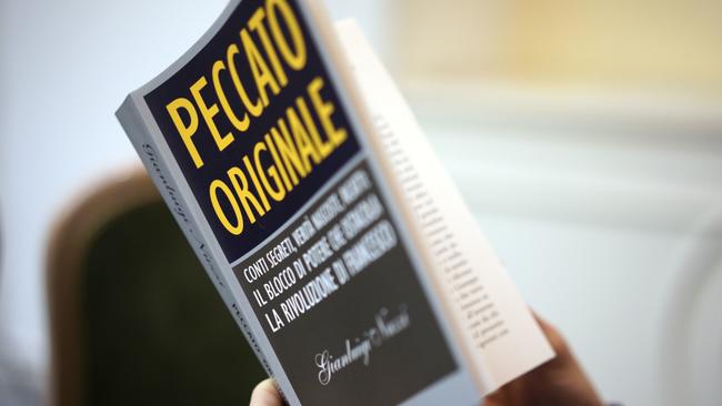 A reporter holds a copy of journalist Gianluigi Nuzzi’s latest book Peccato Originale (Original Sin) during a press conference in Rome on Thursday 9 November 2017. Picture: Andrew Medichini/AP