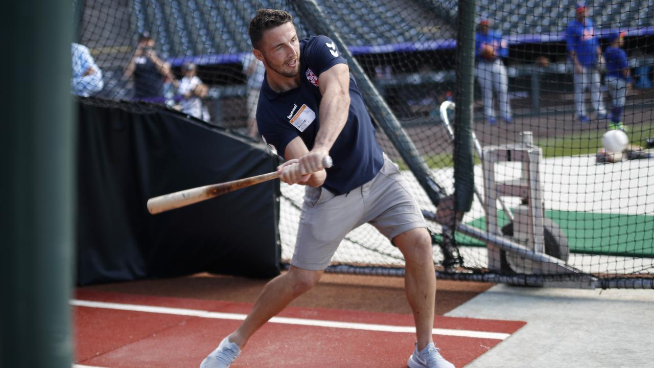 Sam Burgess takes a swing in the batting cage as players watched Colorado Rockies.