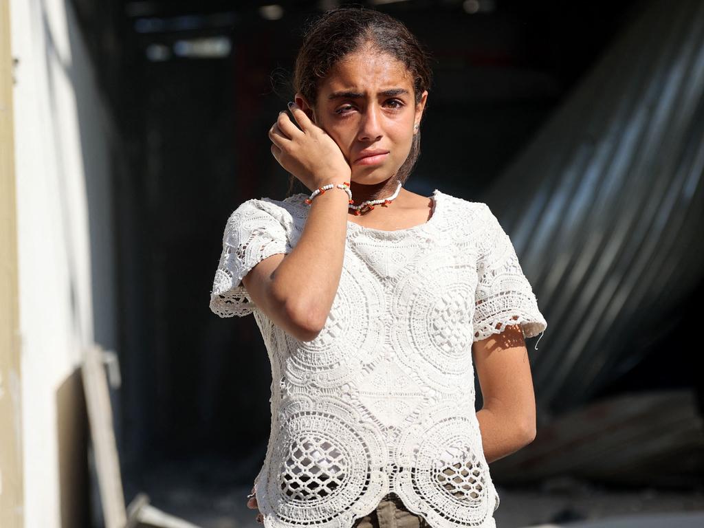 A Palestinians girl cries as she stands in the grounds of the badly damaged Latin Patriarchate Holy Family School after it was hit during Israeli military bombardment in Gaza City. Picture: Omar Al-Qattaa/AFP