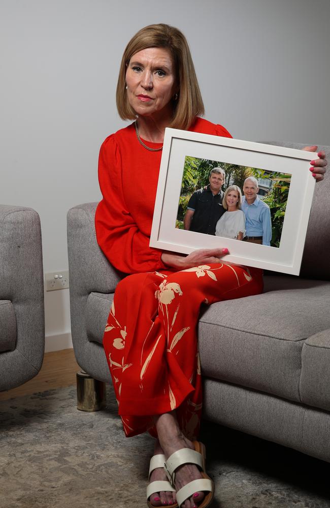 Marita Corbett holds a photo of her and her brothers Derek Luxton (left) and Brendan Luxton (right) who committed suicide after hotel quarantine. Picture: Zak Simmonds