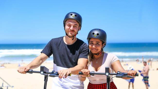 Tourists Alexander Culic and Nusrat Shuprity try out the new RIDE e-scooters which launched on the Gold Coast yesterday. Photo: Supplied.