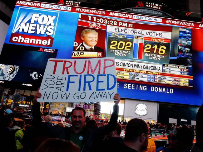 People gather around Times Square to view televised results of the US presidential election on November 8, 2016 in New York. Millions of Americans voted November 8th for their new leader in a historic election that will either elevate Democrat Hillary Clinton as their first woman president or hand power to maverick populist Donald Trump. / AFP PHOTO / EDUARDO MUNOZ ALVAREZ