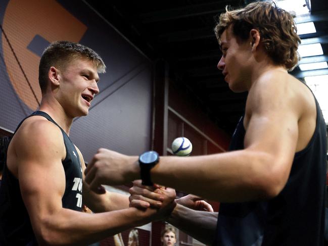 Former No.1 draft pick Aaron Cadman congratulates Gruzewski on making his debut. Picture: Phil Hillyard