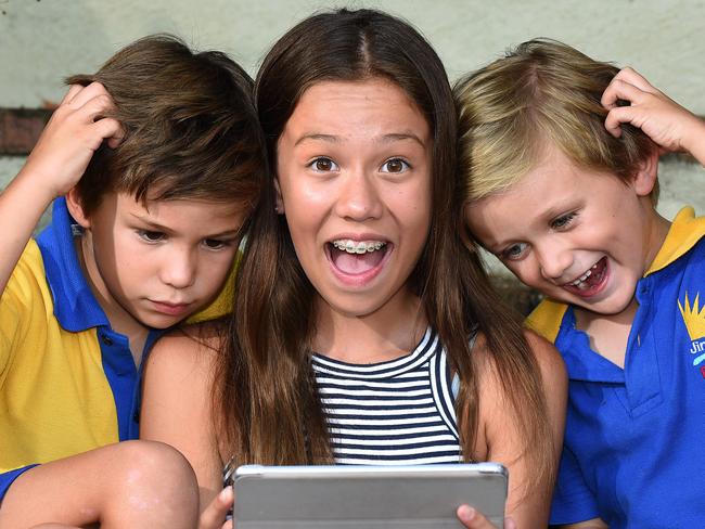 Roman 8, Persia 12 and Leonardis Sanchez age 5 have heads together looking at a tablet.  Head lice prevention. Monday January 22, 2018.  (AAP image, John Gass)