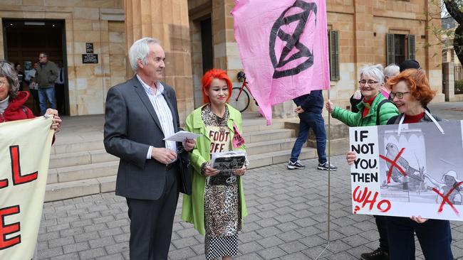 Extinction Rebellion members Ian Fox and Ngoc Nguyen speaking to the media outside the Adelaide Magistrates court after they were sentenced for disturbing the peace. Photo: NCA NewsWire/David Mariuz