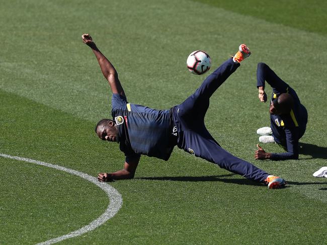 Bolt stretches up during his first training session. Picture: Brett Costello