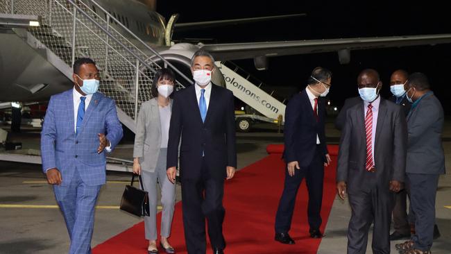 Solomon Island's Foreign Minister Jeremiah Manele, left, escorts Chinese Foreign Minister Wang Yi, centre, upon his arrival at the Henderson International Airport in Honiara.