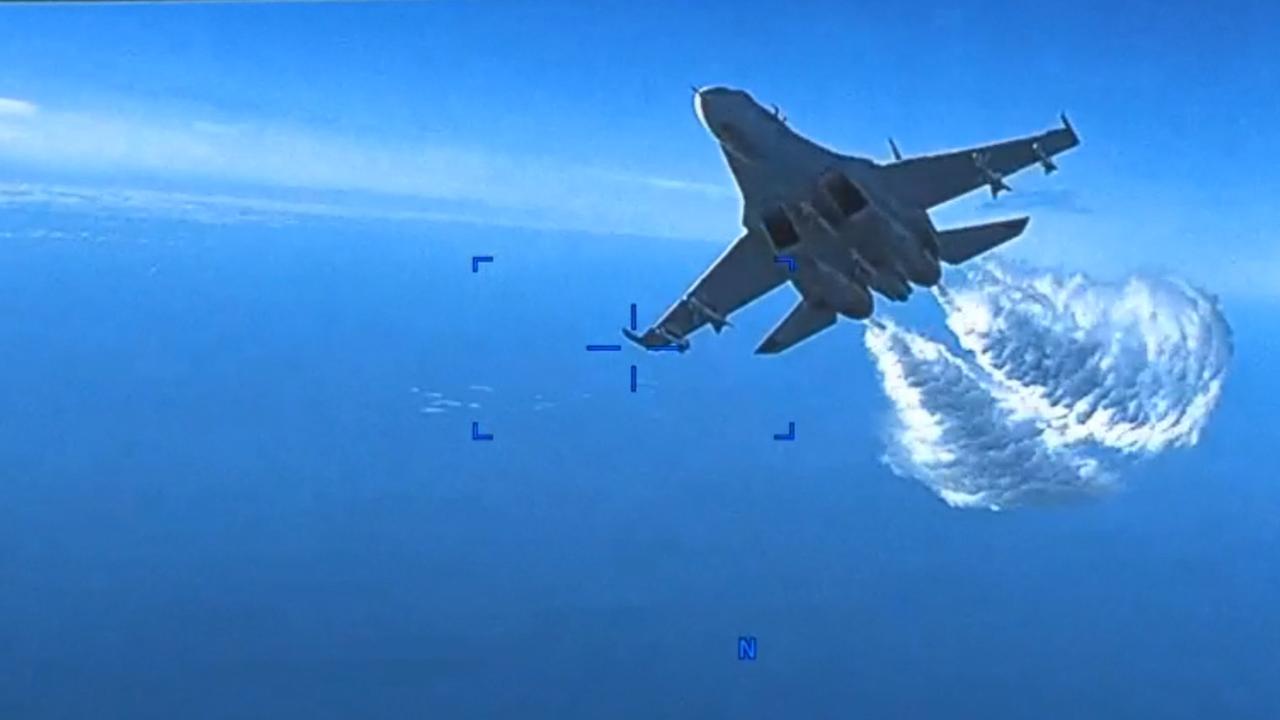 Onboard footage from a US Air Force MQ-9 drone as it is approached by a Russian SU-27 aircraft jettisoning fuel, over The Black Sea on March 14, 2023. (Photo by Handout / USEUCOM / AFP)