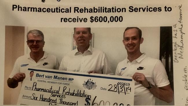 Forde MP Bert van Manen presents Lachlan Foord and Andrew Pfeffer a cheque for $600,000, funds the clinic said it was still waiting to receive.