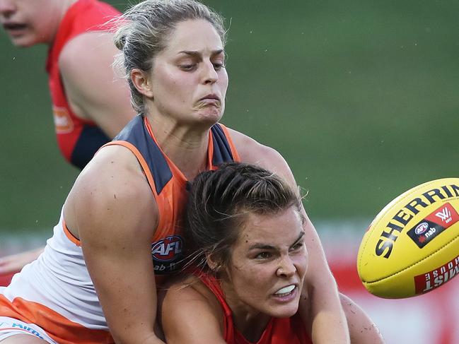 Melbourne's Madeleine Boyd handballs in front of Giants Ellie Brush during Women's AFL match GWS Giants v Melbourne at Blacktown. Picture. Phil Hillyard