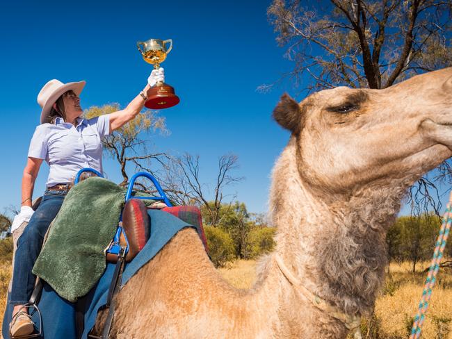 2001 Melbourne Cup winning trainer, Sheila Laxon, holds the Emirates Melbourne Cup aloft on Pixie the camel at the Pyndan Camel Farm just outside Alice Springs.