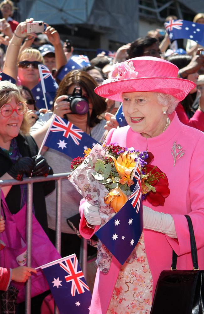 2011: Queen Elizabeth II receives flowers from the crowd during her visit to Federation Square in downtown Melbourne on October 26, 2011. Picture: ALEX COPPEL / POOL / AFP