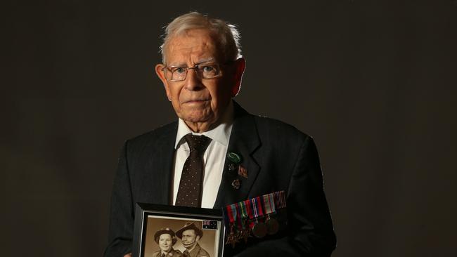 Charles Harris holding a picture of his sister Ronda and brother George. Both siblings also served in the war. Picture: George Salpigtidis