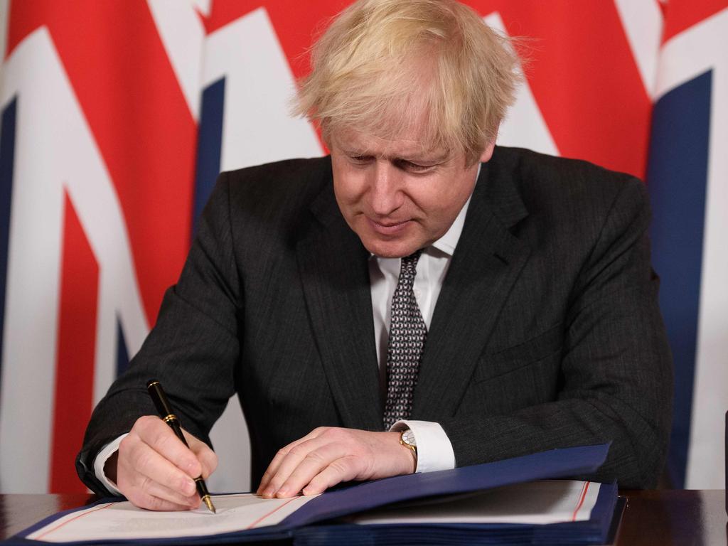 Britain's Prime Minister Boris Johnson is head down as he signs the Trade and Cooperation Agreement between the UK and the EU. Picture: AFP