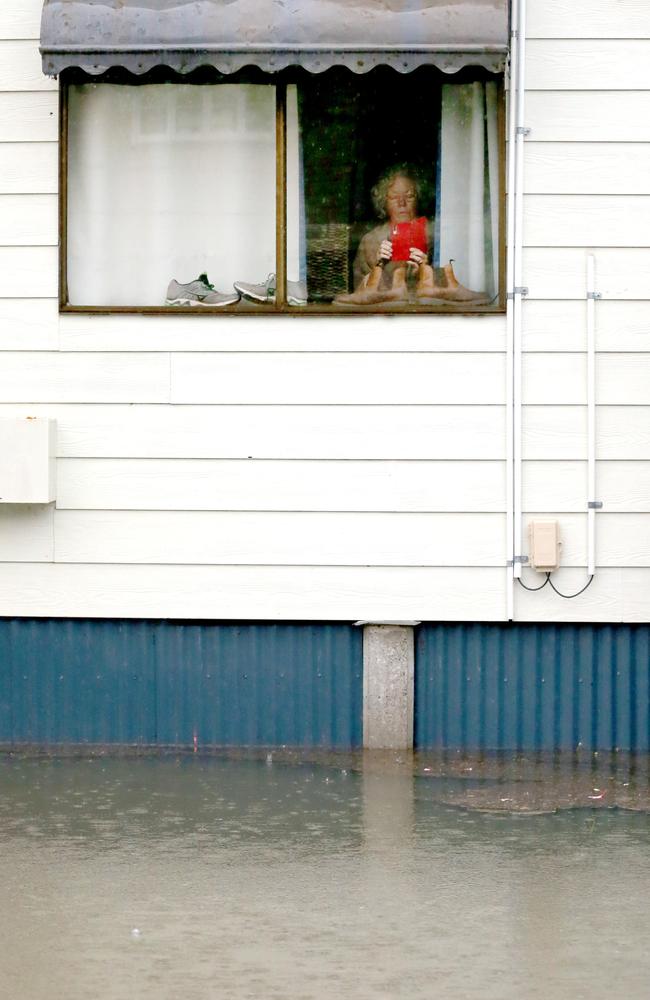 A resident looking out of her window at Torwood St, Milton. Picture: Steve Pohlner