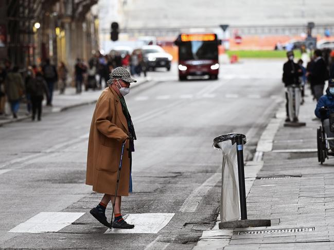 An elderly woman crosses the road in downtown Rome. Picture: AFP