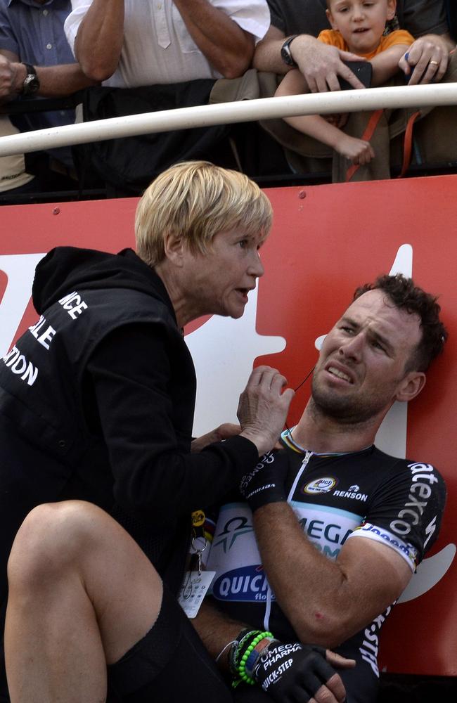 Cavendish clutches his dislocated shoulder as he receives medical assistance.