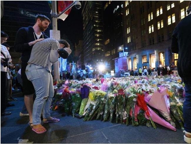 A mourner breaks down in tears and is comforted by her partner at Martin Place in Sydney following the deadly siege that took place at the Lindt Cafe. Picture: Richard Dobson