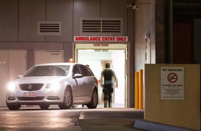 The police officer who shot Kumanjayi Walker wearing a bullet proof vest enters the Alice Springs Hospital after an Royal Flying Doctors Plane landed from Yuendumu on Saturday night. Picture: EMMA MURRAY