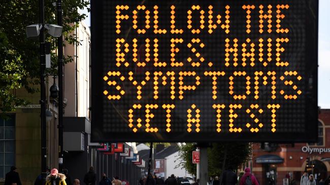 A woman walks near an electronic road sign displaying COVID-19 information reading "Follow the Rules. Have Symptoms, Get A Test", in Bolton in northwest England. The UK government recently imposed tougher coronavirus restrictions in northwest England, as it voiced fears about rising infection rates among younger people. Picture: Oli Scarff/AFP