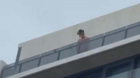 A young person appearing to urinate from the roof of the building.