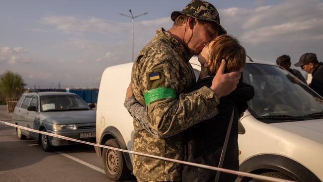 A Ukrainian soldier kisses his wife, who he had not seen for nearly a year, after she fled from the Russian-occupied eastern village of Novomykhailivka and arrived by car at an evacuation point in Zaporizhzhia. Picture: Getty Images