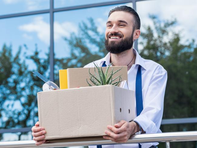 happy businessman with cardboard box with office supplies in hands standing outside office building, quitting job concept. quit job happy. ISTOCK