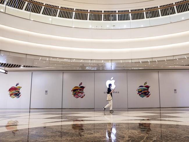 WUHAN, CHINA - APRIL 11: (CHINA OUT) A person wears a mask while they pass the logo board of the new Apple store on April 11, 2022 in Wuhan, Hubei province, China. According to local media reports, this is the first Apple store to open in Wuhan while it's the 44th in the mainland. (Photo by Getty Images)